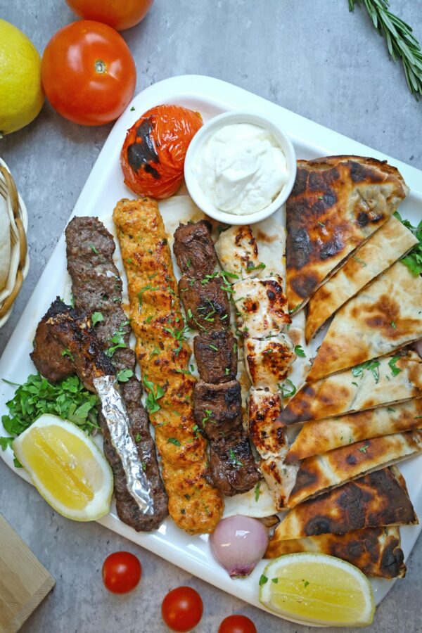 A mouth-watering assortment of grilled meats served with pita bread and fresh lemon.