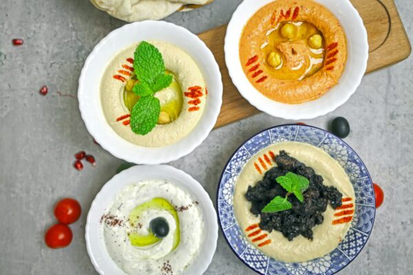 A delicious selection of Middle Eastern dips served in bowls, perfect for healthy eating.