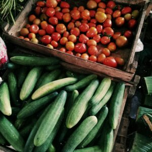 Vibrant tomatoes and cucumbers on display at a local farmers market.