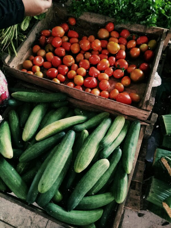 Vibrant tomatoes and cucumbers on display at a local farmers market.