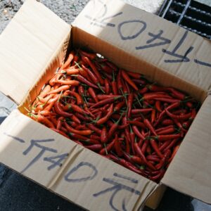 Open box of vibrant red chili peppers captured at a street market in Taipei, Taiwan.