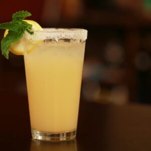 Chilled lemon-mint cocktail with a sugared rim, perfect for summer refreshment.