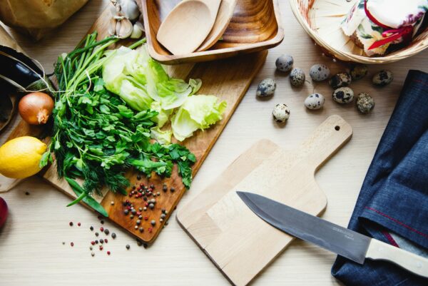 A collection of fresh vegetables and quail eggs arranged on a wooden kitchen surface.