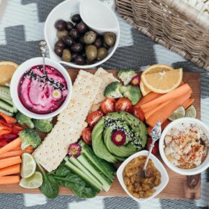 Colorful vegan platter featuring fresh vegetables, dips, and olives. Perfect for a healthy snack or party.