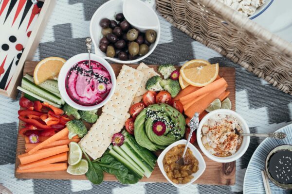 Colorful vegan platter featuring fresh vegetables, dips, and olives. Perfect for a healthy snack or party.