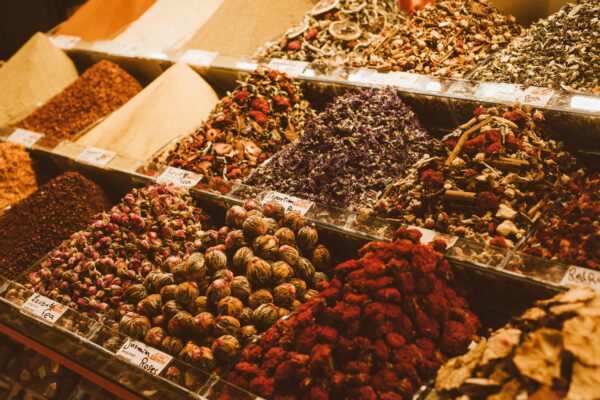 A detailed display of colorful spices, teas, and herbs at a market stall.