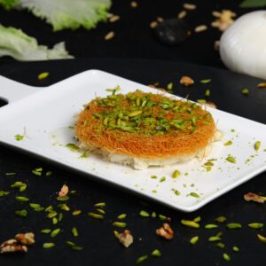 Close-up of mouthwatering Arabic Kunafa topped with chopped pistachios.